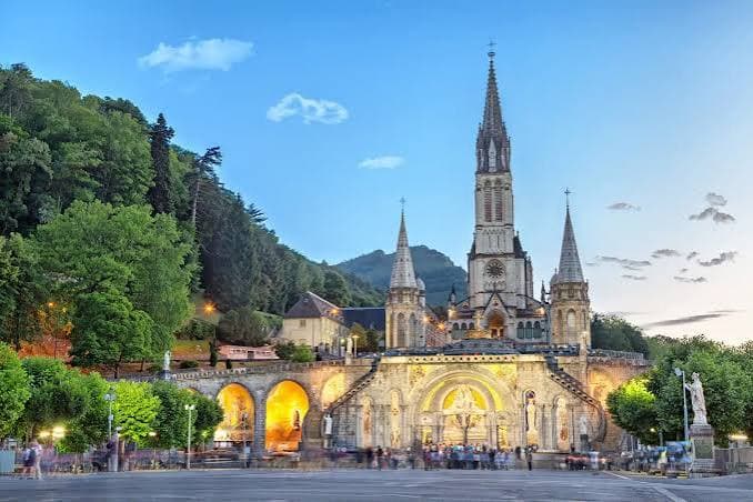 La basilique Notre-Dame du Rosaire illuminée à la tombée du soir, aux Sanctuaires de Lourdes