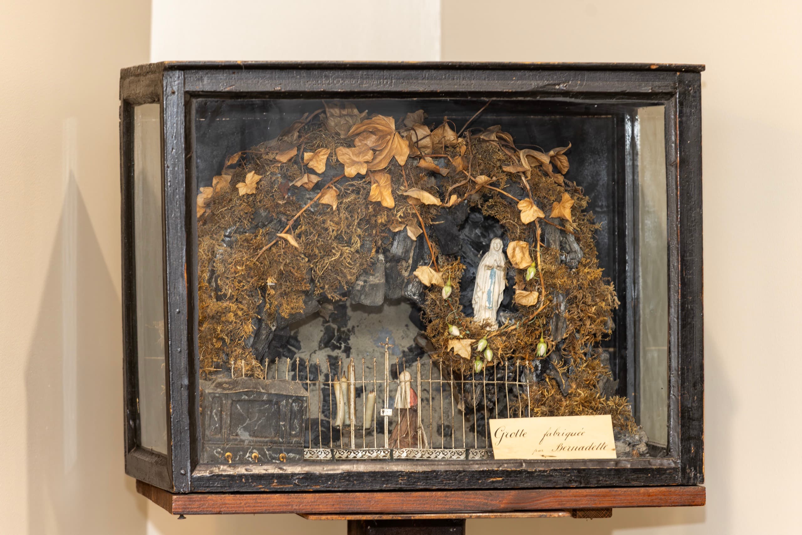 La petite grotte sculptée par Bernadette, sous sa vitrine ancienne